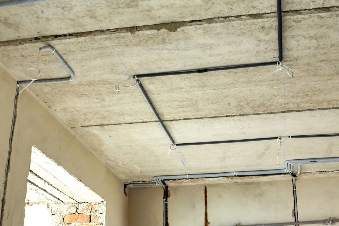 Instalacja elektryczna rozprowadzona po surowym suficie i ścianach przed tynkowaniem